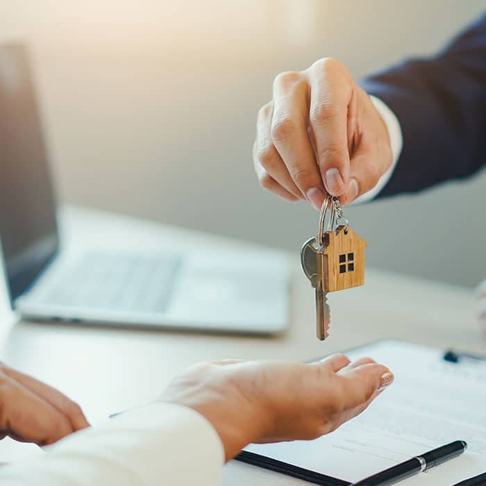 man holding key waiting for person to grab it